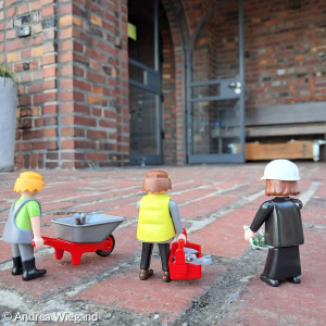 Spielfiguren mit Handwerkzeug gehen zum Eingang der Kreuzkirche