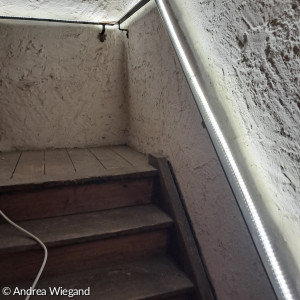 Lichterkete am Handlauf im Treppenaufgang zum Turm