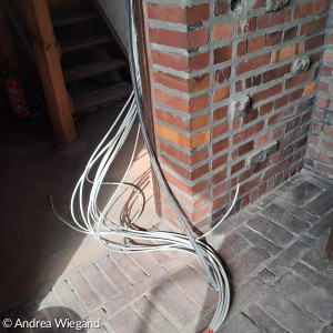 Ein Bündel Elektrokabel schlängelt sich aus dem Kirchturm