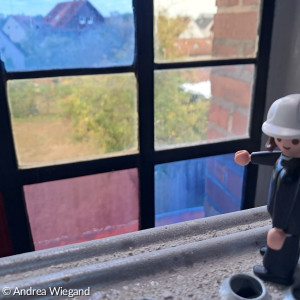Figur Herr Luther auf dem Gerüst vor den bunten Glasfenstern